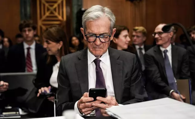 Federal Reserve Board Chairman Jerome Powell uses his phone before a Senate Committee on Banking hearing, Wednesday, June 25, 2025, on Capitol Hill in Washington. (AP Photo/Julia Demaree Nikhinson)