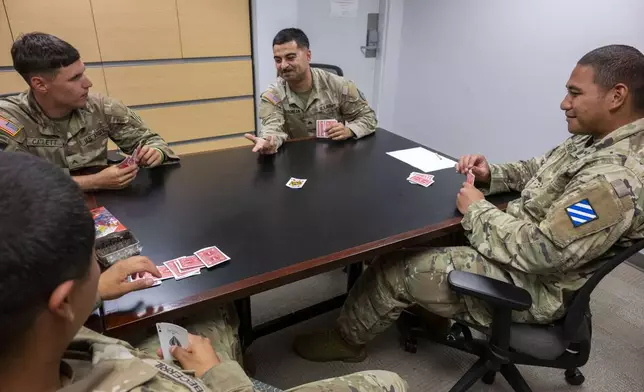 Army soldiers play cards in the USO that has been set up for the up to 5,000 soldiers who will be quartered in the GSA Regional Office Building for the Army's 250th Birthday celebration, Sunday, June 8, 2025, in Washington. (AP Photo/Kevin Wolf)