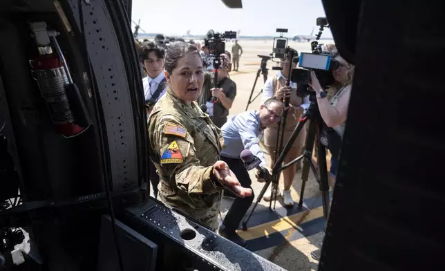 Army Sgt. Victoria Robinson speaks to the press outside a U.S. Army UH-60M Black Hawk helicopter that will participate in an upcoming military parade commemorating the Army's 250th anniversary and coinciding with President Donald Trump's 79th birthday, at Joint Base Andrews, Md., Thursday, June 12, 2025. (AP Photo/Mark Schiefelbein)