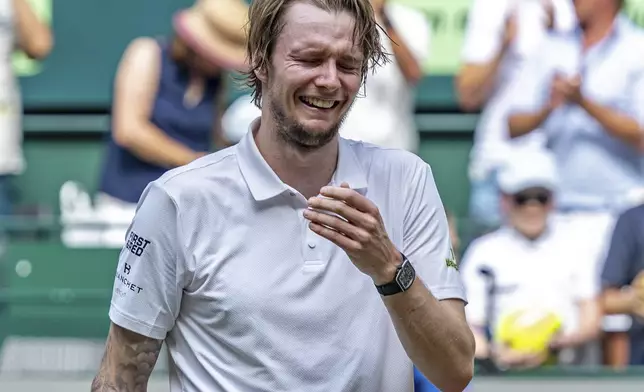 Kazakhstan's Alexander Bublik reacts after defeating Russia's Daniil Medvedev in their men's single final of the Halle tennis tournament, Germany, Sunday, June 22, 2025. (David Inderlied/dpa via AP)