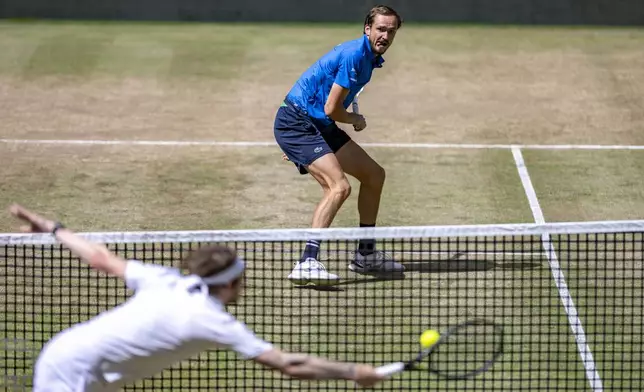 Kazakhstan's Alexander Bublik, bottom left, returns the ball to Russia's Daniil Medvedev during their men's single final of the Halle tennis tournament, Germany, Sunday, June 22, 2025. (David Inderlied/dpa via AP)