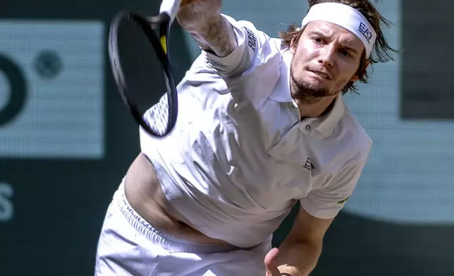 Kazakhstan's Alexander Bublik serves the ball to Russia's Daniil Medvedev during their men's single final of the Halle tennis tournament, Germany, Sunday, June 22, 2025. (David Inderlied/dpa via AP)