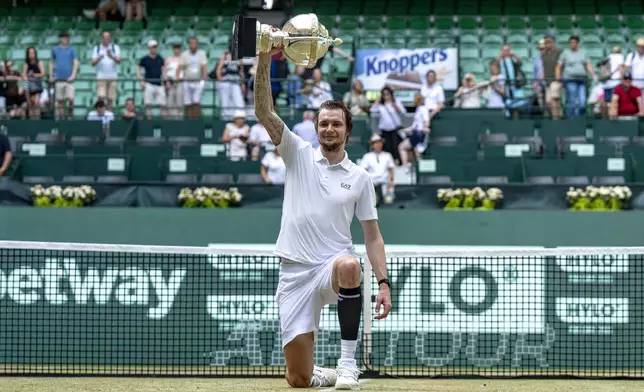 Kazakhstan's Alexander Bublik holds the trophy after defeating Russia's Daniil Medvedev in their men's single final of the Halle tennis tournament, Germany, Sunday, June 22, 2025. (David Inderlied/dpa via AP)