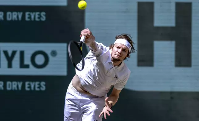Kazakhstan's Alexander Bublik serves a ball to Russia's Daniil Medvedev during their men's single final of the Halle tennis tournament, Germany, Sunday, June 22, 2025. (David Inderlied/dpa via AP)