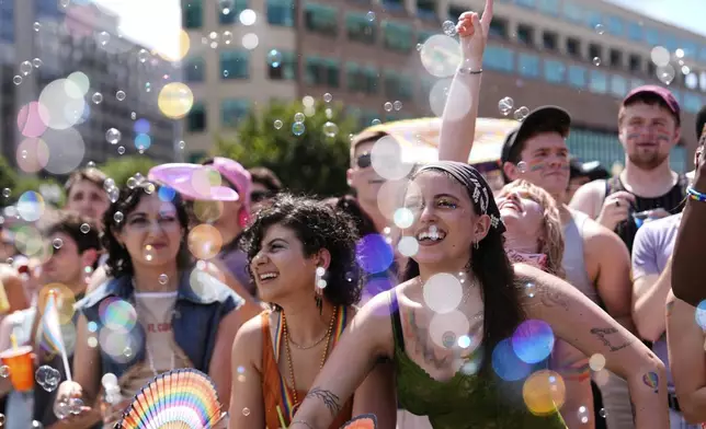 People watch the World Pride parade, Saturday, June 7, 2025, in Washington. (AP Photo/Julia Demaree Nikhinson)