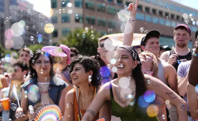 People watch the World Pride parade, Saturday, June 7, 2025, in Washington. (AP Photo/Julia Demaree Nikhinson)