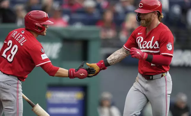 Cincinnati Reds' Jake Fraley, right, is congratulated by teammate TJ Friedl (29) after hitting a home run in the fourth inning of a baseball game against the Cleveland Guardians in Cleveland, Monday, June 9, 2025. (AP Photo/Sue Ogrocki)