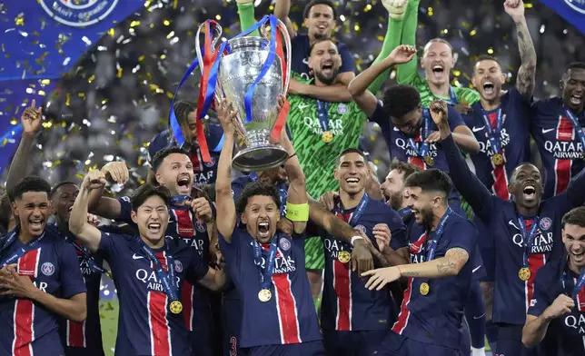 PSG players celebrate with the trophy after winning the Champions League final soccer match between Paris Saint-Germain and Inter Milan at the Allianz Arena in Munich, Germany, Saturday, May 31, 2025. (AP Photo/Matthias Schrader)