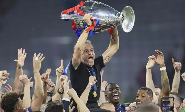 PSG's head coach Luis Enrique lifts the trophy after the Champions League final soccer match between Paris Saint-Germain and Inter Milan at the Allianz Arena in Munich, Germany, Saturday, May 31, 2025. (AP Photo/Alexandra Beier)