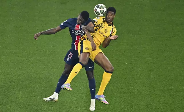 Nuno Mendes of PSG, left, and Inter's Denzel Dumfries battle for the ball during the Champions League final soccer match between Paris Saint Germain and Inter Milan, at the Allianz Arena in Munich, Germany, Saturday, May 31, 2025. (Peter Kneffel/dpa via AP)