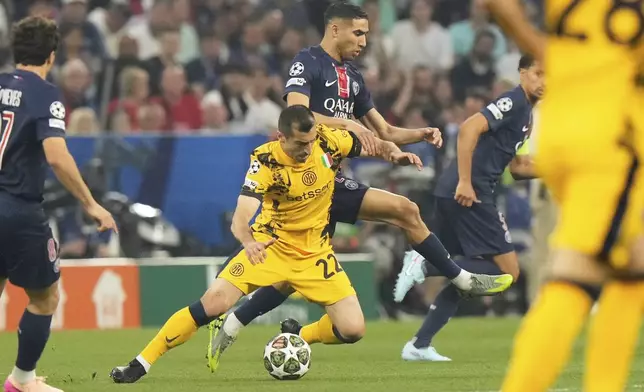 PSG's Achraf Hakimi, background, fights for the ball with Inter Milan's Henrikh Mkhitaryan during the Champions League final soccer match between Paris Saint-Germain and Inter Milan at the Allianz Arena in Munich, Germany, Saturday, May 31, 2025. (AP Photo/Luca Bruno)