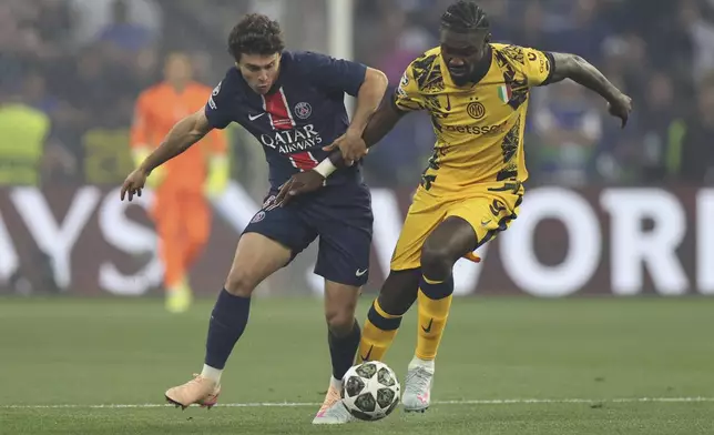 PSG's Joao Neves. left, and Inter Milan's Marcus Thuram fight for the ball during the Champions League final soccer match between Paris Saint-Germain and Inter Milan at the Allianz Arena in Munich, Germany, Saturday, May 31, 2025. (AP Photo/Alexandra Beier)