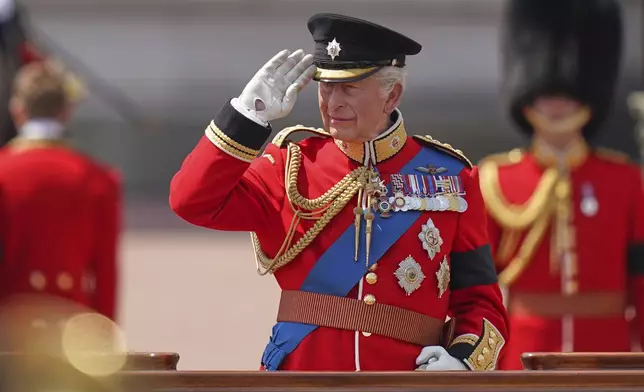Britain's King Charles salutes troops as they match past during the Trooping the Colour in London, Saturday, June 14, 2025, the king is wearing a black armband as a mark of respect to the victims of the Air India plane crash. (AP Photo/Alberto Pezzali)