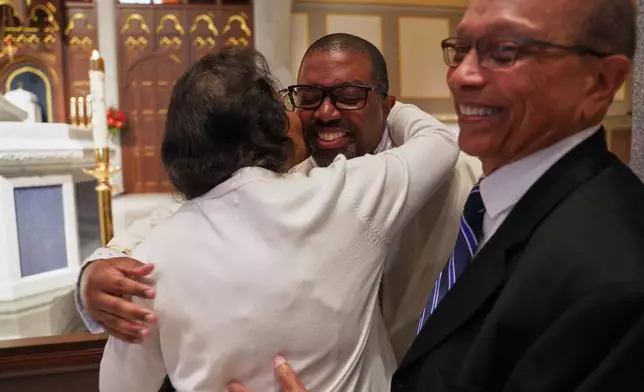 The Rev. Ricky Malebranche, center, hugs his parents, Margaret and Jacques Malebranche, after being ordained a priest at the Cathedral of Saint Thomas More in Arlington, Va., on Saturday, June 7, 2025. (AP Photo/Jessie Wardarski)