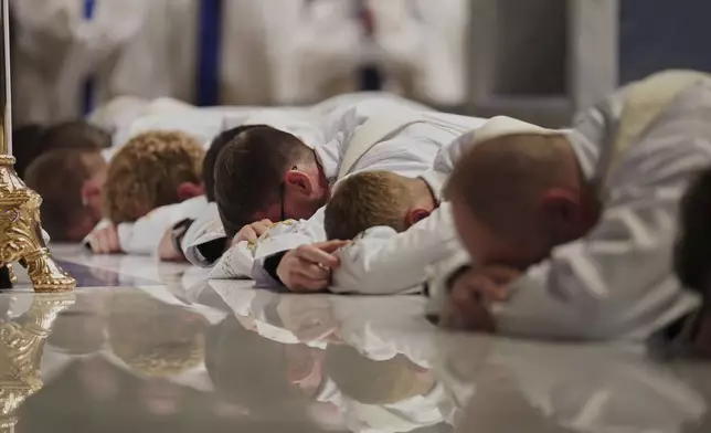 Twelve deacons prostrate in front of the altar at the Cathedral of Saint Thomas More during their ordination Mass in Arlington, Va., on Saturday, June 7, 2025. (AP Photo/Jessie Wardarski)