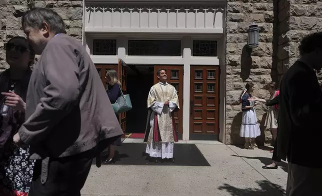 The Rev. Alfredo Tuesta smiles after greeting congregants at the end of a Mass at St. James Catholic Church, Falls Church, Va., on Sunday, May 24, 2025. (AP Photo/Luis Andres Henao)