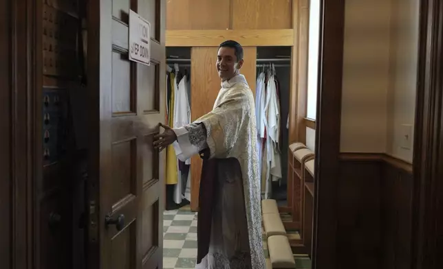 The Rev. Alfredo Tuesta opens the door to the sacristy after a Mass at St. James Catholic Church, Falls Church, Va., on Sunday, May 24, 2025. (AP Photo/Luis Andres Henao)