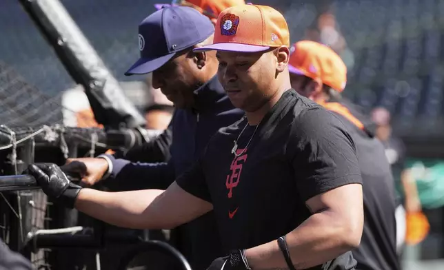 San Francisco Giants infielder Rafael Devers, foreground, waits to hit during batting practice after talking with former player Barry Bonds, left, before a baseball game between the Giants and the Cleveland Guardians in San Francisco, Tuesday, June 17, 2025. (AP Photo/Jeff Chiu)