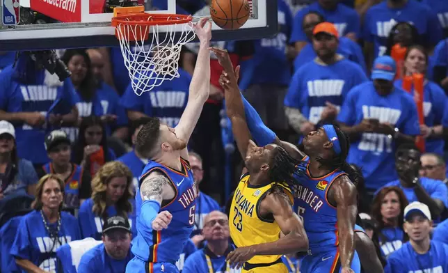 Indiana Pacers forward Aaron Nesmith (23) shoots against Oklahoma City Thunder center Isaiah Hartenstein (55) and guard Luguentz Dort (5) during the second half of Game 2 of the NBA Finals basketball series Sunday, June 8, 2025, in Oklahoma City. (AP Photo/Kyle Phillips)