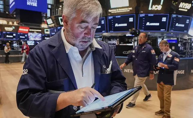 Trader Edward McCarthy, left, works on the floor of the New York Stock Exchange, Monday, June 23, 2025. (AP Photo/Richard Drew)