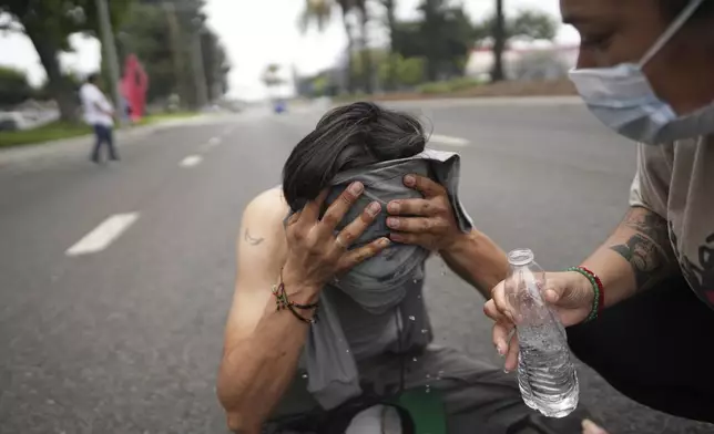 A protester is given aid during a demonstration over the dozens detained in an operation by federal immigration authorities a day earlier in Paramount section of Los Angeles Saturday, June 7, 2025. (AP Photo/Eric Thayer)
