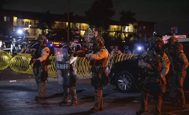 Los Angeles County Sheriffs stand during a protest in Compton, Calif., Saturday, June 7, 2025, after federal immigration authorities conducted operations. (AP Photo/Ethan Swope)