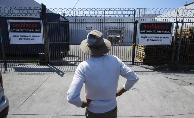 A man stands outside a business where federal immigration authorities conducted an operation on Friday, June 6, 2025, in Los Angeles. (AP Photo/Damian Dovarganes)