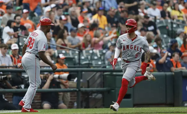 Los Angeles Angels' Zach Neto (9) scores a run on a double hit by Taylor Ward against pitcher Tomoyuki Sugano during the fifth inning of a baseball game in Baltimore, Saturday, June 14, 2025. (AP Photo/Terrance Williams)