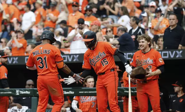 Baltimore Orioles' Cedric Mullins (31) is greeted by Dylan Carlson (15) after hitting a two run home run against Los Angeles Angels pitcher Tyler Anderson during the sixth inning of a baseball game in Baltimore, Saturday, June 14, 2025. (AP Photo/Terrance Williams)