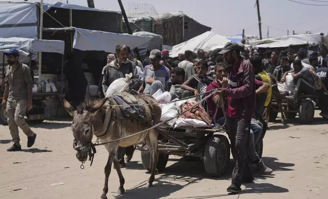 Palestinians carry bags containing food and humanitarian aid packages delivered by the Gaza Humanitarian Foundation, a U.S.-backed organization, in Rafah, southern Gaza Strip, Monday, June 16, 2025. (AP Photo/Abdel Kareem Hana)