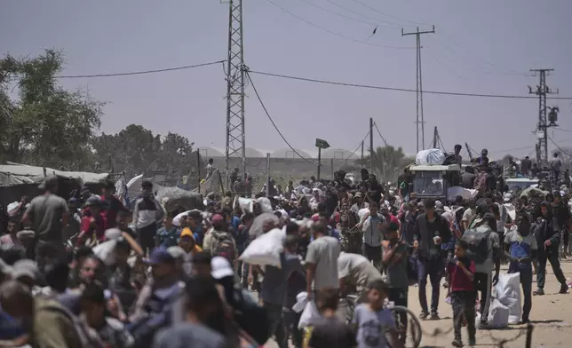 Palestinians carry bags containing food and humanitarian aid packages delivered by the Gaza Humanitarian Foundation, a U.S.-backed organization, in Rafah, southern Gaza Strip, Monday, June 16, 2025. (AP Photo/Abdel Kareem Hana)
