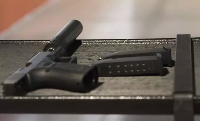 FILE - A handgun with a silencer and two magazines are shown at a gun range in Atlanta, Jan. 27, 2017. (AP Photo/Lisa Marie Pane, File)