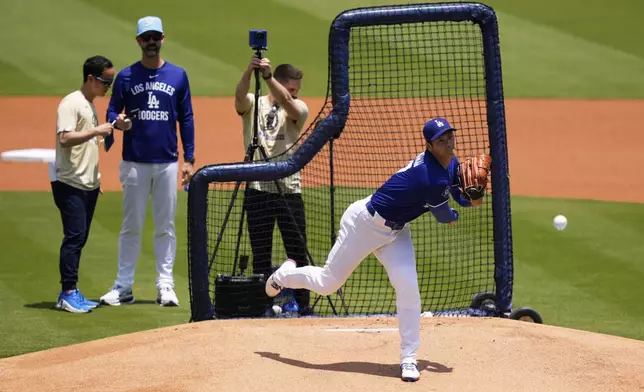 Los Angeles Dodgers' pitcher Shohei Ohtani, center, throws live batting practice as pitching coach Mark Prior, second from left, watches prior to a baseball game against the New York Yankees, Saturday, May 31, 2025, in Los Angeles. (AP Photo/Mark J. Terrill)