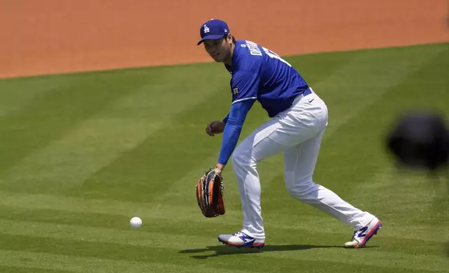 Los Angeles Dodgers' pitcher Shohei Ohtani fields a hit ball while he was throwing to live batters practice prior to a baseball game against the New York Yankees, Saturday, May 31, 2025, in Los Angeles. (AP Photo/Mark J. Terrill)