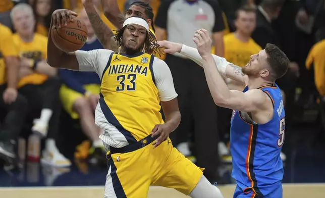 Indiana Pacers center Myles Turner (33) rebounds over Oklahoma City Thunder center Isaiah Hartenstein during the first half of Game 6 of the NBA Finals basketball series, Thursday, June 19, 2025, in Indianapolis. (AP Photo/Michael Conroy)