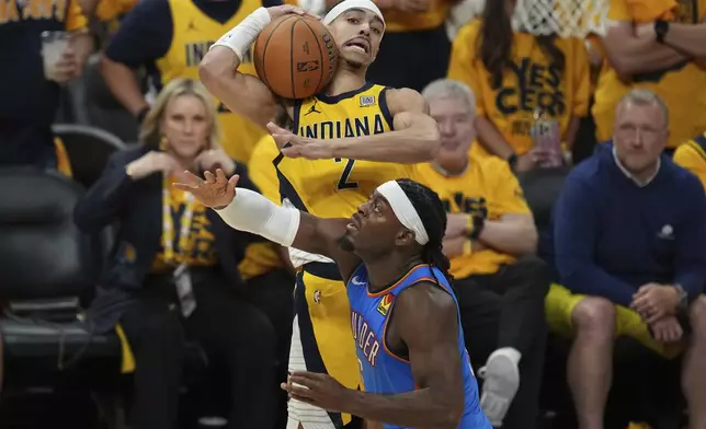 Indiana Pacers guard Andrew Nembhard (2) rebounds over Oklahoma City Thunder guard Luguentz Dort during the second half of Game 6 of the NBA Finals basketball series, Thursday, June 19, 2025, in Indianapolis. (AP Photo/Michael Conroy)