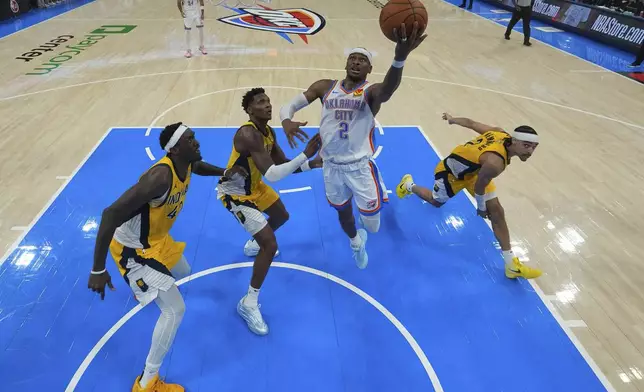 Oklahoma City Thunder guard Shai Gilgeous-Alexander (2) shoots past Indiana Pacers forward Pascal Siakam, left, and Indiana Pacers guard Andrew Nembhard, right, during the second half of Game 5 of the NBA Finals basketball series, Monday, June 16, 2025, in Oklahoma City. (AP Photo/Nate Billings)