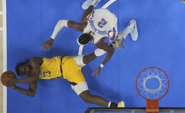 Indiana Pacers forward Aaron Nesmith (23) controls the ball against Oklahoma City Thunder guard Shai Gilgeous-Alexander (2) during the second half of Game 5 of the NBA Finals basketball series, Monday, June 16, 2025, in Oklahoma City. (Kyle Terada/Pool Photo via AP)
