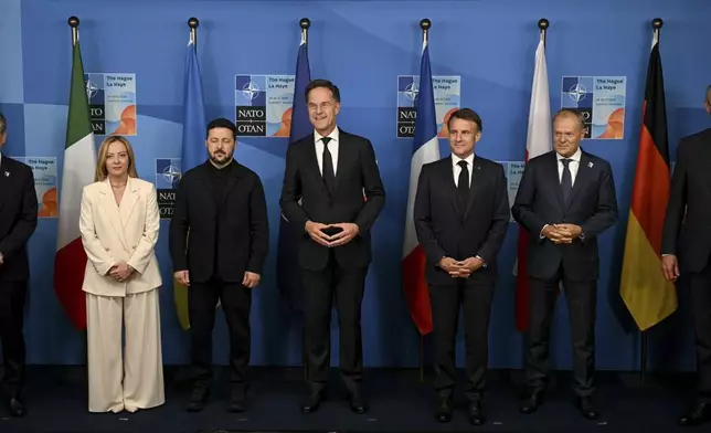 Britain's Prime Minister Keir Starmer, from left, Italy's Prime Minister Giorgia Meloni, Ukraine's President Volodymyr Zelenskyy, NATO Secretary General Mark Rutte, France's President Emmanuel Macron, Poland's Prime Minister Donald Tusk and Germany's Chancellor Friedrich Merz pose for a family picture during the meeting between the Nato secretary general and Ukrainian president with leaders of E5 Group on the sideline of the NATO summit in The Hague, Netherlands, Wednesday, June 25, 2025. (Ben Stansall/Pool Photo via AP)