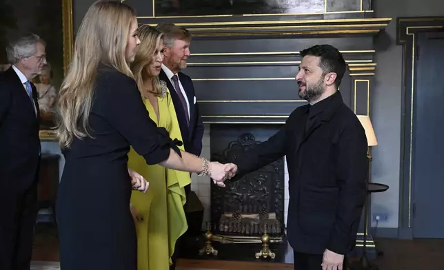 Ukraine's President Volodymyr Zelenskyy, right, is welcomed by Netherland's King Willem Alexander and Netherland's Queen Maxima as he arrives for a formal dinner at the Paleis Huis ten Bosch ahead of the NATO summit in The Hague, Netherlands, Tuesday, June 24, 2025. (Misha Schoemakers, Pool Photo via AP)