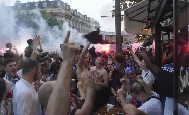 Supporters celebrate a PSG goal outside a cafe during the the Champions League final soccer match between Paris Saint-Germain and Inter Milan, Saturday, May 31, 2025 in Paris. (AP Photo/Aurelien Morissard)