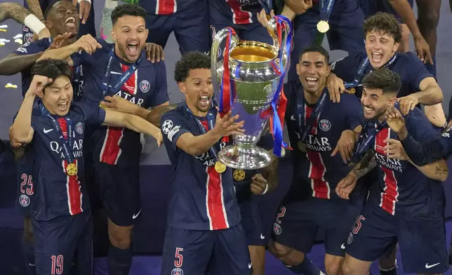 PSG's Marquinhos celebrates with the trophy after winning the Champions League final soccer match between Paris Saint-Germain and Inter Milan at the Allianz Arena in Munich, Germany, Saturday, May 31, 2025. (AP Photo/Michael Probst)