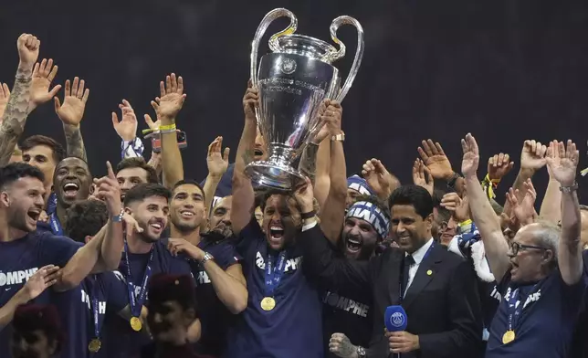PSG's team captain Marquinhos holds the trophy during a celebration at the Parc des Princes stadium after the team won the Champions League final soccer match between Paris Saint-Germain and Inter Milan Sunday, June 1, 2025 in Paris. (AP Photo/Michel Euler)