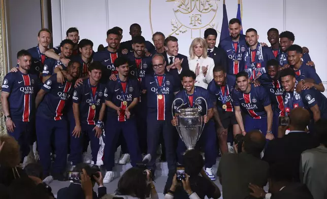 French President Emmanuel Macron, center left, his wife Brigitte Macron, pose with the PSG team after the team won the Champions League final soccer match between Paris Saint-Germain and Inter Milan Sunday, June 1, 2025 at the Elysee Palace in Paris. (AP Photo/Thomas Padilla, Pool)