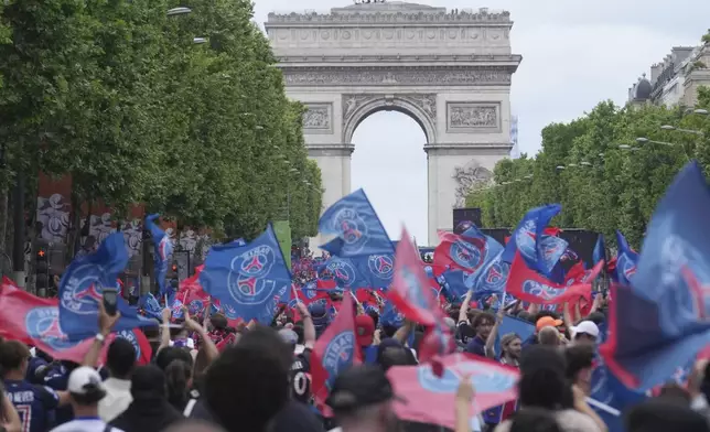 PSG supporters invade the Champs-Elysees avenue, with de Arc de Triomphe in background, before a PSG players' parade after the team won the Champions League final soccer match between Paris Saint-Germain and Inter Milan Sunday, June 1, 2025 in Paris. (AP Photo/Thibault Camus)