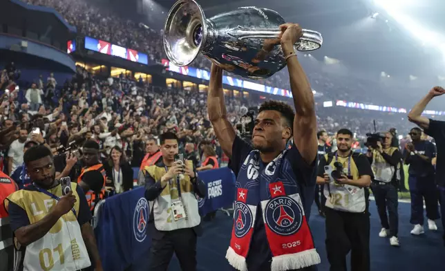 Paris Saint-Germain's midfielder Desire Doue celebrates with supporters during a ceremony to present the trophy a day after Paris Saint-Germain (PSG) won the UEFA Champions League, at the Parc des Princes Stadium in Paris Sunday, June 1, 2025. (Franck Fife, Pool via AP)