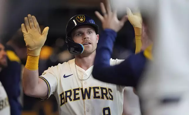 Milwaukee Brewers' Jake Bauers is congratulated in the dugout after hitting a solo home run during the sixth inning of a baseball game against the Atlanta Braves, Tuesday, June 10, 2025, in Milwaukee. (AP Photo/Aaron Gash)