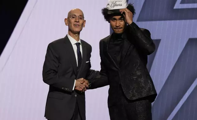 Dylan Harper poses for a photo with NBA commissioner Adam Silver after being selected second by the San Antonio Spurs In the first round of the NBA basketball draft, Wednesday, June 25, 2025, in New York. (AP Photo/Adam Hunger)