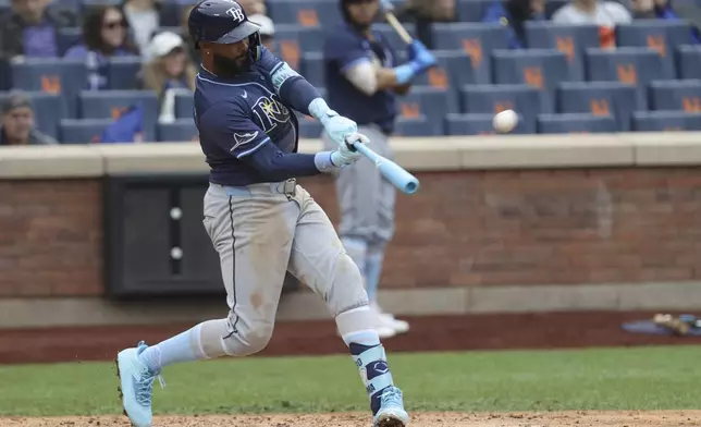 Tampa Bay Rays' Junior Caminero hits a home run, leading Taylor Walls and Brandon Lowe to score, during the ninth inning of a baseball game against the New York Mets, Sunday, June 15, 2025, in New York. (AP Photo/Pamela Smith)