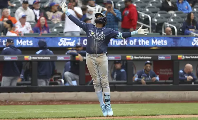Tampa Bay Rays' Junior Caminero reacts after hitting a home run leading Taylor Walls and Brandon Lowe to score during the ninth inning of a baseball game against the New York Mets Sunday, June 15, 2025, in New York. (AP Photo/Pamela Smith)